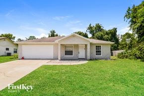 Deltona house for rent - a white house with a lawn and a driveway