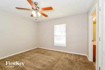 Deltona house for rent - a living room with carpet and a ceiling fan
