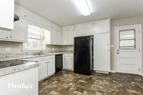 Marietta house for rent - a white kitchen with white cabinets and a black refrigerator
