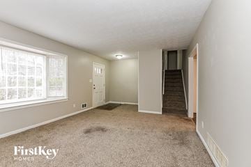 Marietta house for rent - the living room of a house with carpet and a staircase