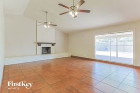 Chandler house for rent - an empty living room with a fireplace and a ceiling fan
