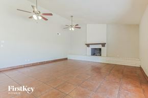 Chandler house for rent - a empty living room with a fireplace and two ceiling fans