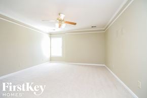 Memphis house for rent - a empty living room with a ceiling fan and a white carpet