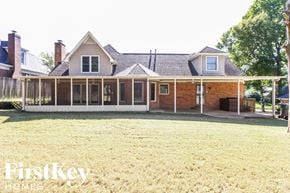 Memphis house for rent - a house with a screened porch and a grass yard