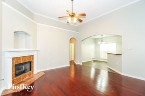 Memphis house for rent - A spacious room with a fireplace and a ceiling fan.