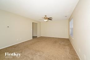 Franklin house for rent - A carpeted room with a ceiling fan and a door.