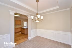 Atlanta house for rent - an empty dining room with white wainscoting and a chandelier