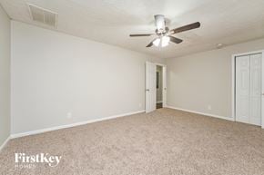 Decatur house for rent - A spacious room with a carpeted floor and a ceiling fan.
