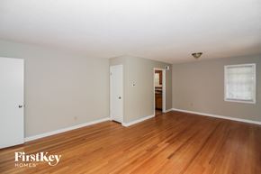 Bartlett house for rent - A room with wooden floors and white walls, with a window on the right wall.