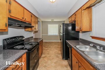 Bartlett house for rent - A kitchen with wooden cabinets and black appliances.