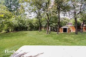 Bartlett house for rent - A backyard with a shed and trees.