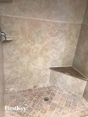 Naples house for rent - A shower area with a tiled floor and walls.