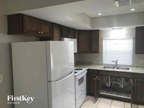 Naples house for rent - A kitchen with a white refrigerator and a stove top oven.