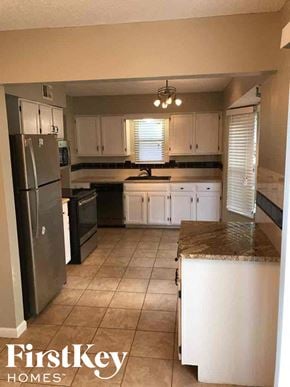 Blue Springs house for rent - a kitchen with white cabinets and a stainless steel refrigerator
