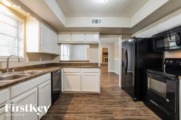 Oak Ridge North house for rent - a kitchen with black appliances and white cabinets