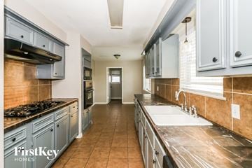 Spring house for rent - A kitchen with a stove top oven and a sink.