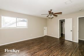 Spring house for rent - A spacious room with a ceiling fan and wooden flooring.