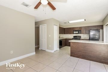 Homestead house for rent - a kitchen with an island and a refrigerator and a ceiling fan