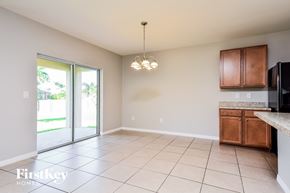 Cape Coral house for rent - A spacious kitchen and living room with a sliding glass door leading to a backyard.