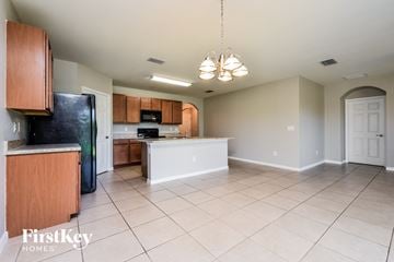 Cape Coral house for rent - A kitchen with wooden cabinets and a black refrigerator.