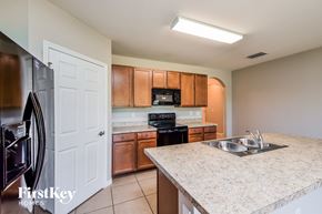 Cape Coral house for rent - A kitchen with a granite countertop and wooden cabinets.