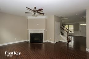Monroe house for rent - A living room with a fireplace and a staircase.