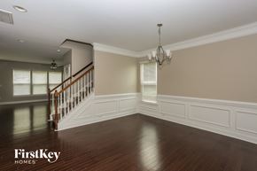 Monroe house for rent - A spacious room with a staircase and a chandelier.
