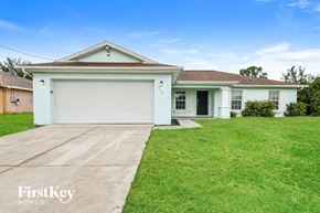 Lehigh Acres house for rent - A white house with a garage door is for sale.