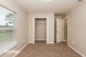 Lehigh Acres house for rent - A bedroom with a carpeted floor and a window with blinds.