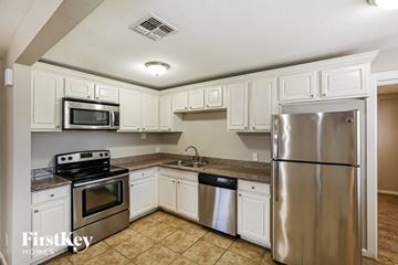 Phoenix house for rent - a kitchen with stainless steel appliances and white cabinets