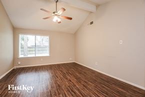 Pearland house for rent - A room with a ceiling fan and wooden flooring.