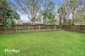 Pearland house for rent - A backyard with a wooden fence and trees.