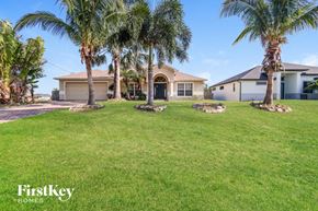 Cape Coral house for rent - a house with palm trees in front of it