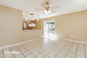Orlando house for rent - an empty living room with a ceiling fan and a door to the kitchen