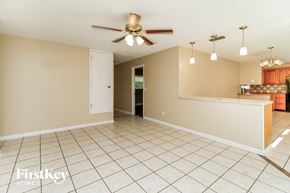 Orlando house for rent - an empty living room with a ceiling fan and a kitchen