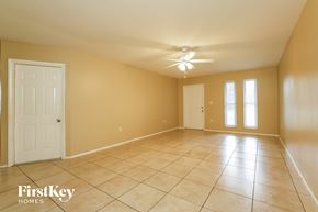 Cape Coral house for rent - a large living room with a tile floor and a ceiling fan