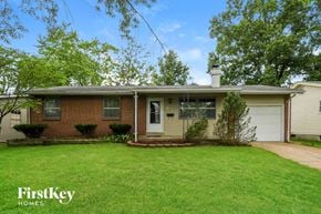 Florissant house for rent - a brick house with a lawn and a white garage door