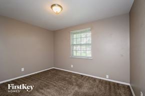 Florissant house for rent - a bedroom with a carpeted floor and a window