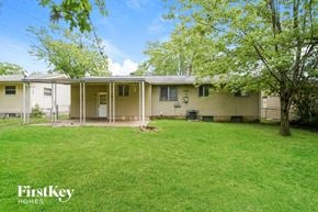 Florissant house for rent - a white and yellow house with a grass yard and trees