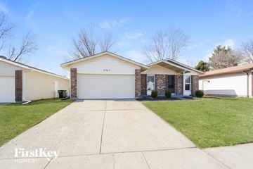 Florissant house for rent - a white and brick house with a driveway and grass