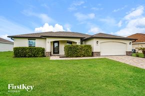 Cape Coral house for rent - A house with a well-maintained lawn and a clear sky above.