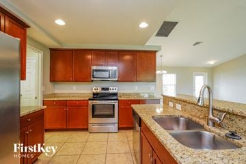 Cape Coral house for rent - A kitchen with brown cabinets and a stainless steel refrigerator.