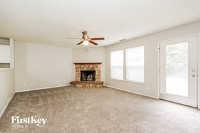 Indianapolis house for rent - A spacious living room with a fireplace and a ceiling fan.