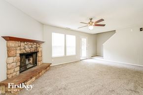 Indianapolis house for rent - A spacious room with a fireplace and a carpeted floor.