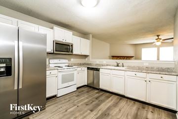 Indianapolis house for rent - A kitchen with white cabinets and a stainless steel refrigerator.