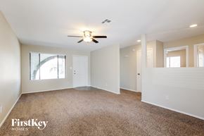 Phoenix house for rent - A spacious room with a ceiling fan and carpeted floor.