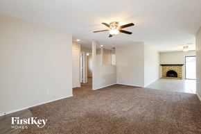 Phoenix house for rent - A spacious living room with a fireplace and a ceiling fan.