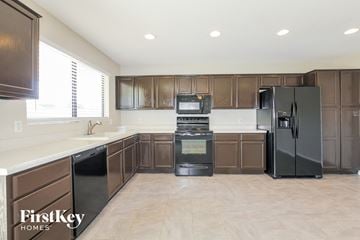Phoenix house for rent - A kitchen with brown cabinets and black appliances.