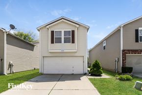 Indianapolis house for rent - a white house with a white garage door and a green lawn