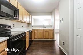 Indianapolis house for rent - an empty kitchen with wooden cabinets and black appliances